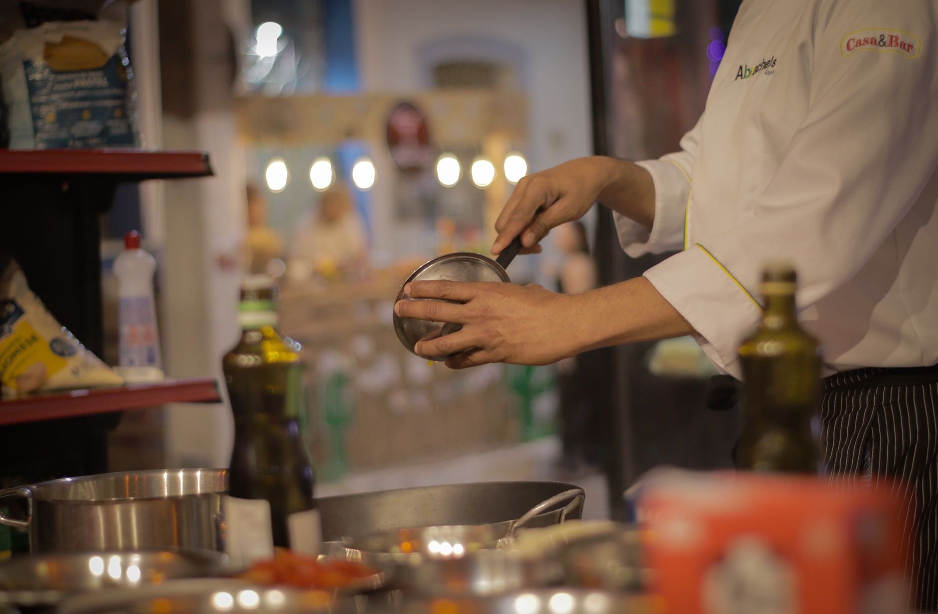 A chef carefully preparing a meal in a warmly lit, cozy restaurant kitchen setting