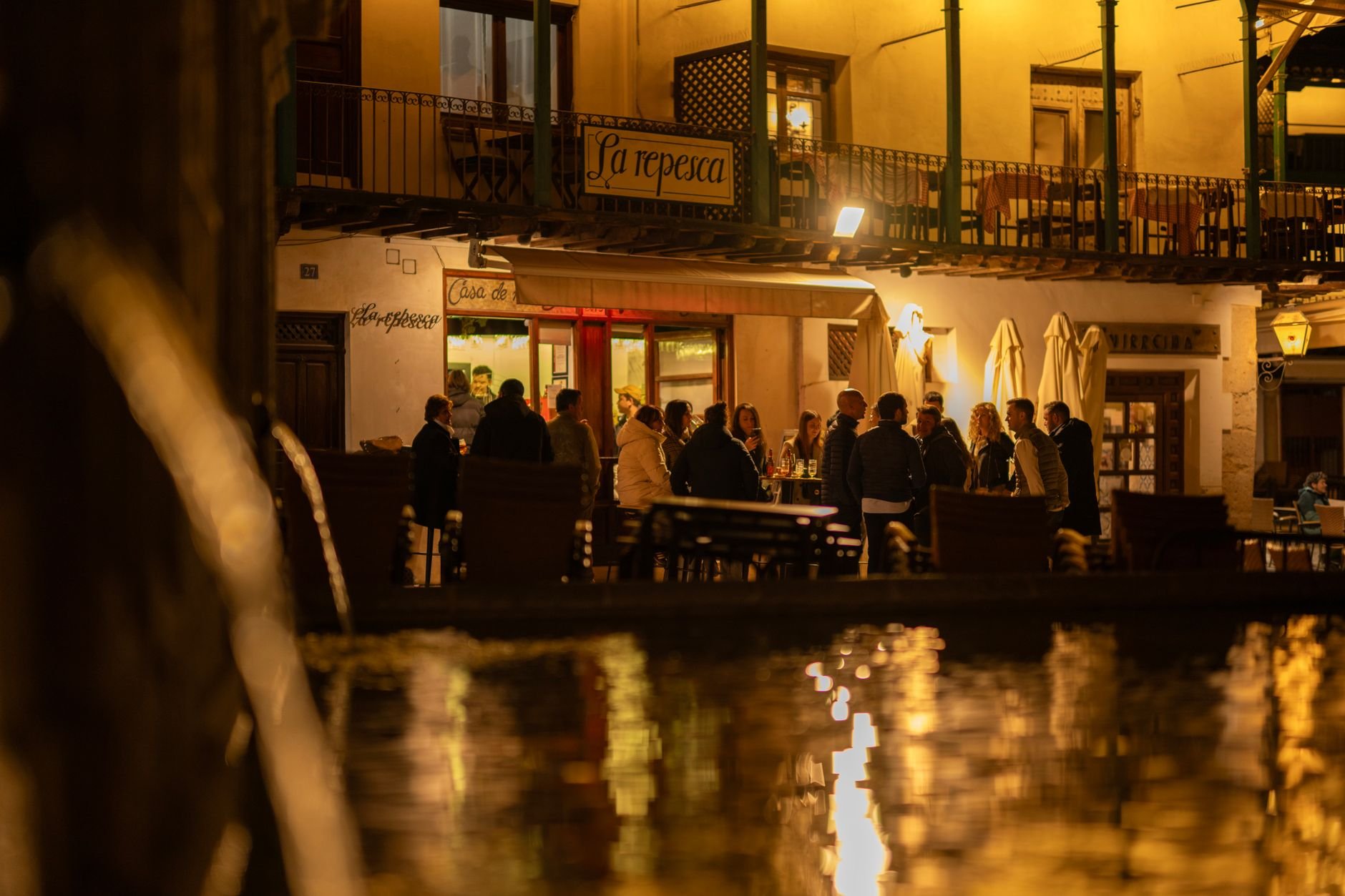 People enjoying an evening meal together at a warm, lively restaurant